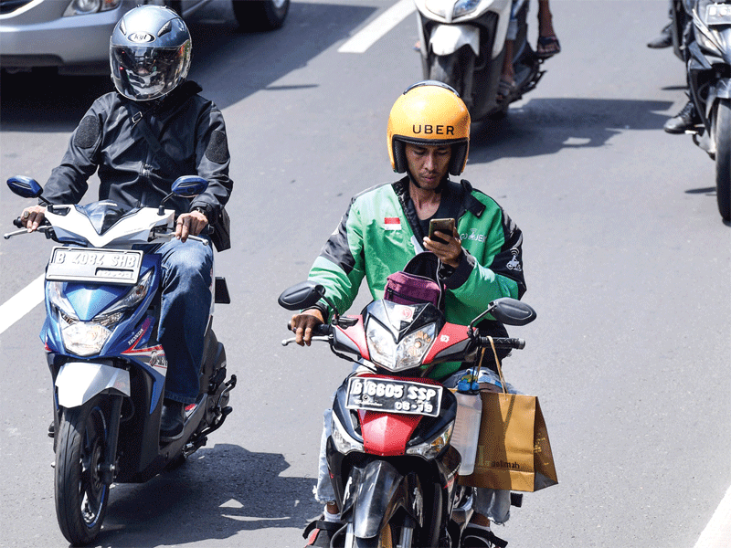 Pengemudi ojek daring mengamati aplikasi GPS (pelacak jalan) pada gawainya saat berkendaraan di Jalan Rasuna Said, Kuningan, Jakarta,kemarin. Polisi akan menilang pengemudi yang menggunakan GPS saat berkemudi karena membahayakan diri sendiri dan pengendara