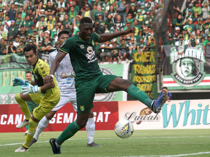 Pesepak bola Persebaya Amido Balde (kanan) berusaha memasukkan bola ke gawang PS Tira Persikabo.