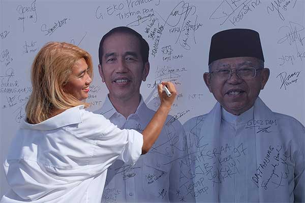 Seorang warga membubuhkan tanda tangan pada poster calon Presiden-Wakil Presiden Jokowi-Ma'ruf Amin dalam Deklarasi Dukungan Alumni SMA/SMK 
