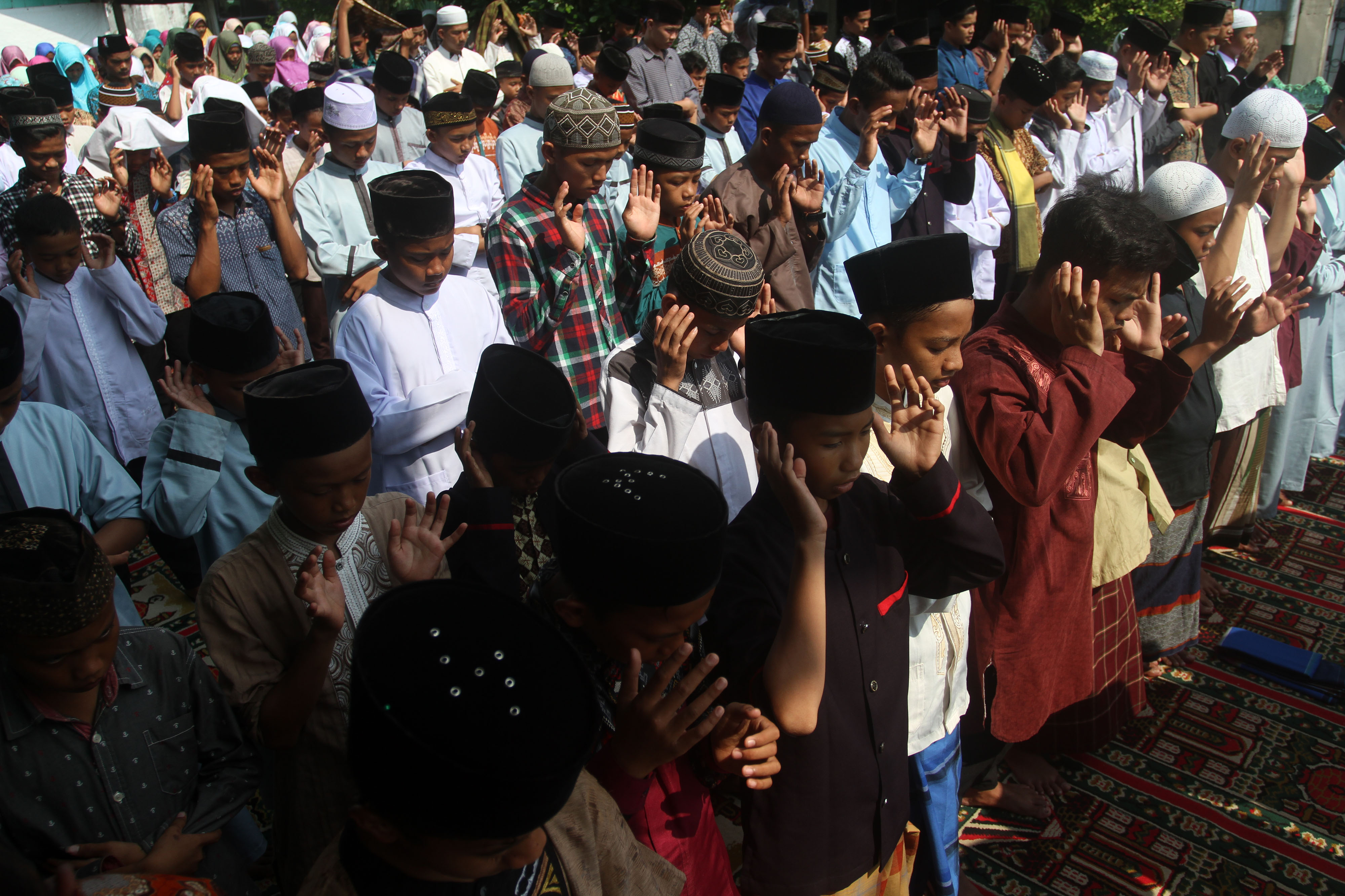 Sejumlah santri melaksanakan Salat Gaib di pelataran parkir kantor Pengurus Wilayah Nahdlatul Ulama Sumatra Barat, Padang, Sumbar, Minggu (17/3). Salat Gaib dan doa bersama itu sebagai wujud kepedulian kepada korban penembakan di dua masjid di kota Christc