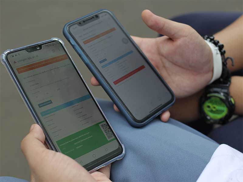 Dua orang siswa Sekolah Menengah Atas Negeri 3 Jakarta menunjukan perbedaan hasil saat mengakses situs resmi Seleksi Nasional Masuk Perguruan Tinggi Negeri (SNMPTN) melalui ponsel pintar, Jakarta, Jumat (22/3). 