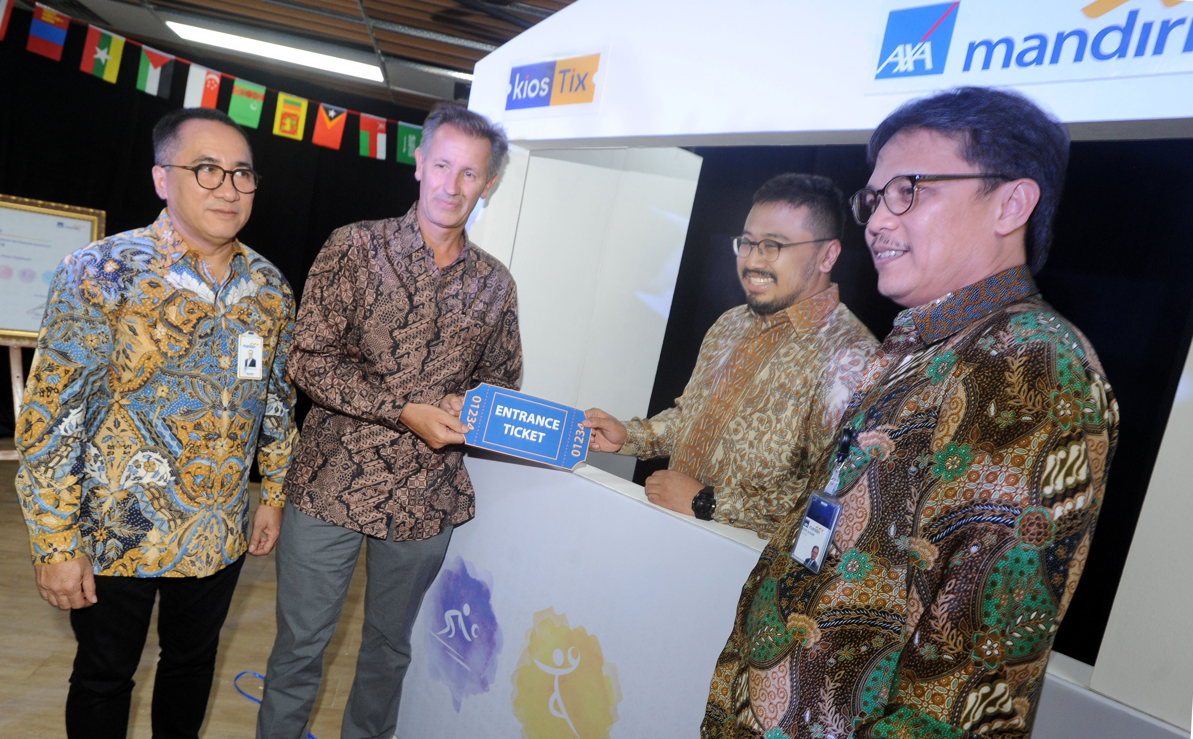 President Director PT Mandiri AXA General Indonesia (MAGI) Paul-Henri Rastoul (kedua kiri) secara simbolis menerima tiket menonton Asian Games 2018 dari CEO PT Pison Tickettech (KiosTix) Ade Sulistioputra (kedua kanan) disaksikan Chief of Sales and Distrib