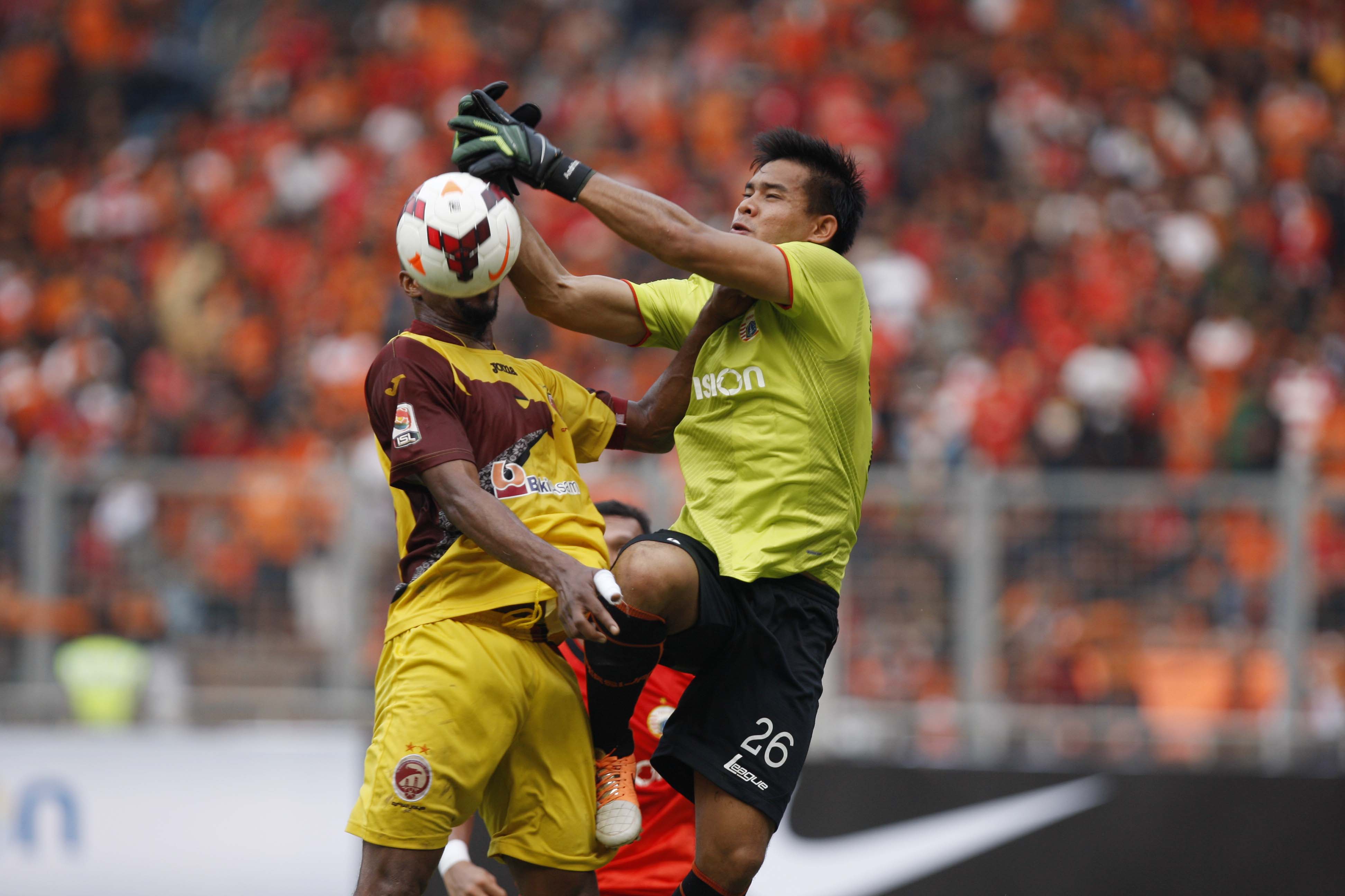 Penjaga gawang Persija Andritany (kanan) berebut bola dengan pemain Sriwijaya FC Lancine Kone ketika laga lanjutan Indonesia Super League di Stadion Utama Gelora Bung Karno, Senayan, Jakarta, Minggu (9/3). Persija yang bermain di hadapan 21 ribu suporter T