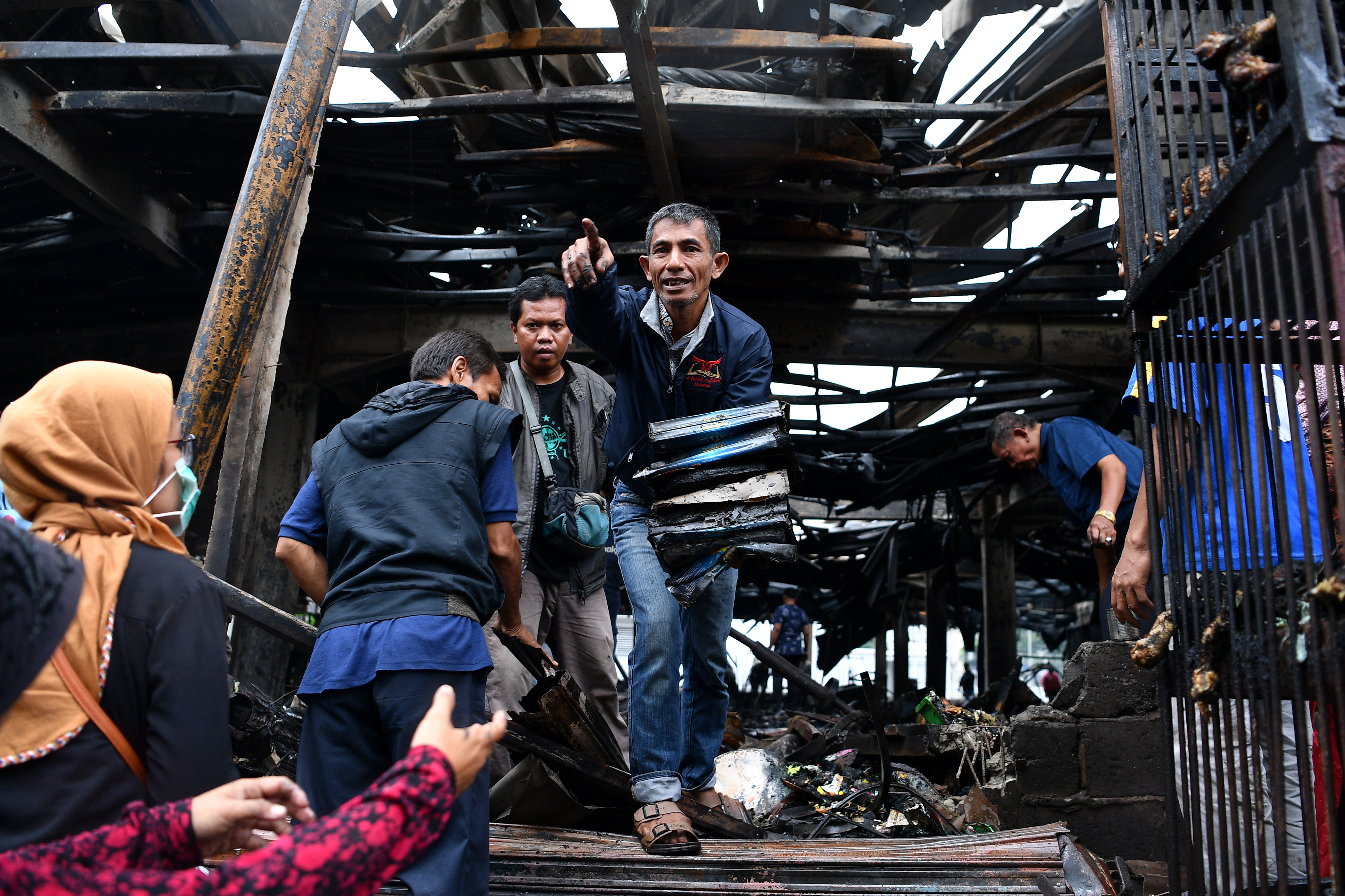 Warga membawa barang dari sisa kebakaran di Tempat Penampungan Sementara Pasar Blok A, Kebayoran Baru, Jakarta Selatan