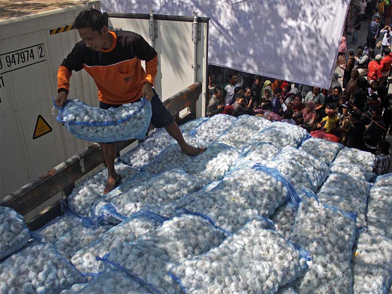 Warga antre membeli bawang putih saat berlangsungnya operasi pasar bawang putih di pasar induk Osowilangun, Surabaya, Jawa Timur, Jumat (19/5). 