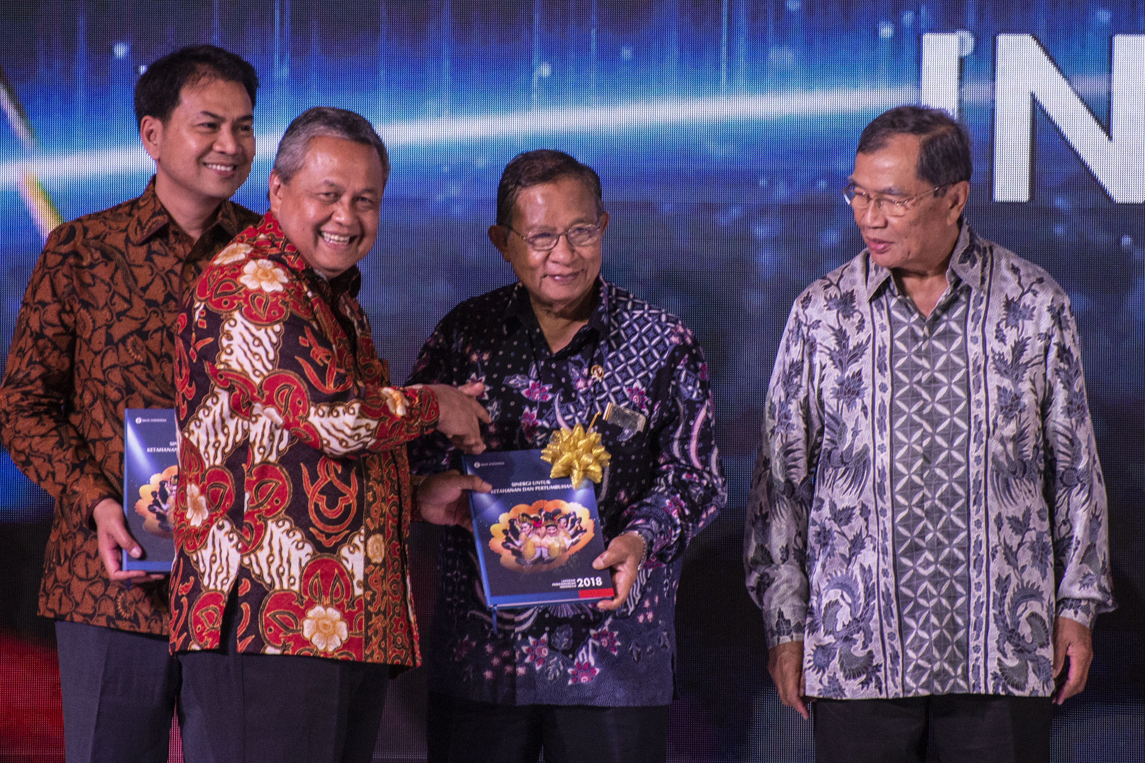 Gubernur BI Perry Warjiyo (kedua kiri) memberikan Buku Laporan Perekonomian Indonesia 2018 kepada Menko Perekonomian Darmin Nasution.