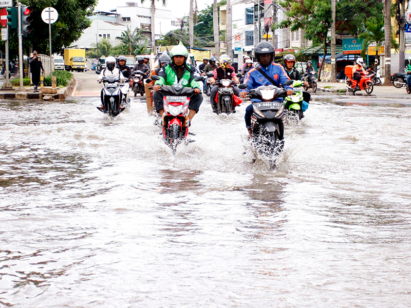 Sejumlah pengendara melewati banjir di depan Green Garden, Jalan Panjang, Jakarta, Jumat (26/2)