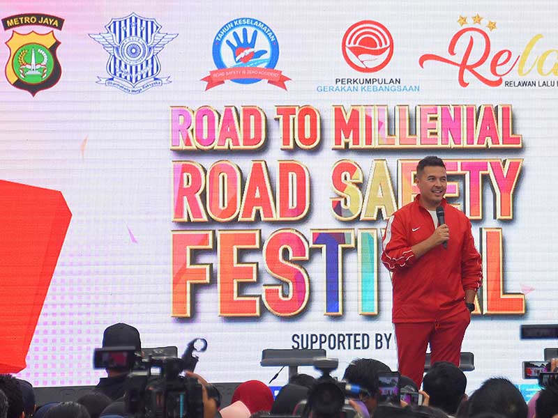 Pebalap Rifat Sungkar (kiri) berbicara mengenai keselamatan berkendara pada kegiatan Millenial Road Safety Festival saat hari bebas berkendara di Bundaran HI, Jakarta, Minggu (20/1/2019). 