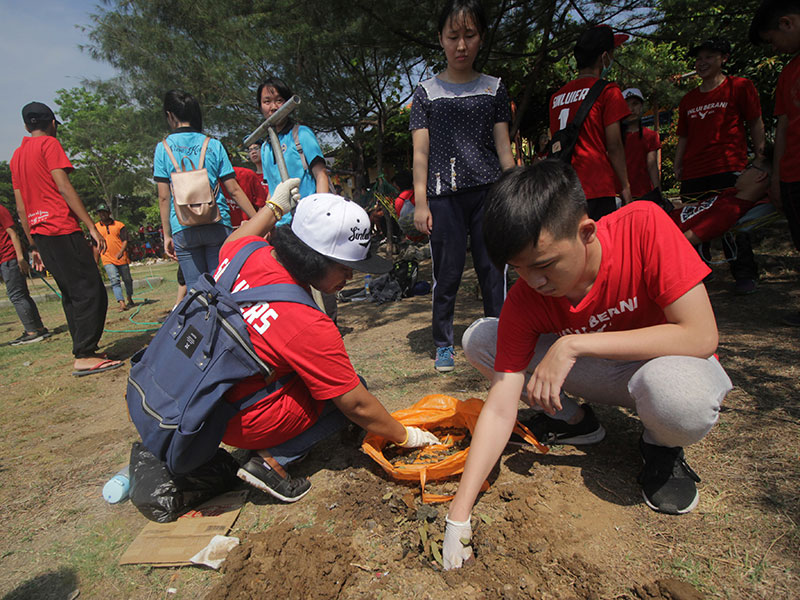 EDUKASI LINGKUNGAN HIDUP: Sejumlah murid SMA Katolik St Louis 1 Surabaya membuat lubang resapan biopori saat melakukan aksi 