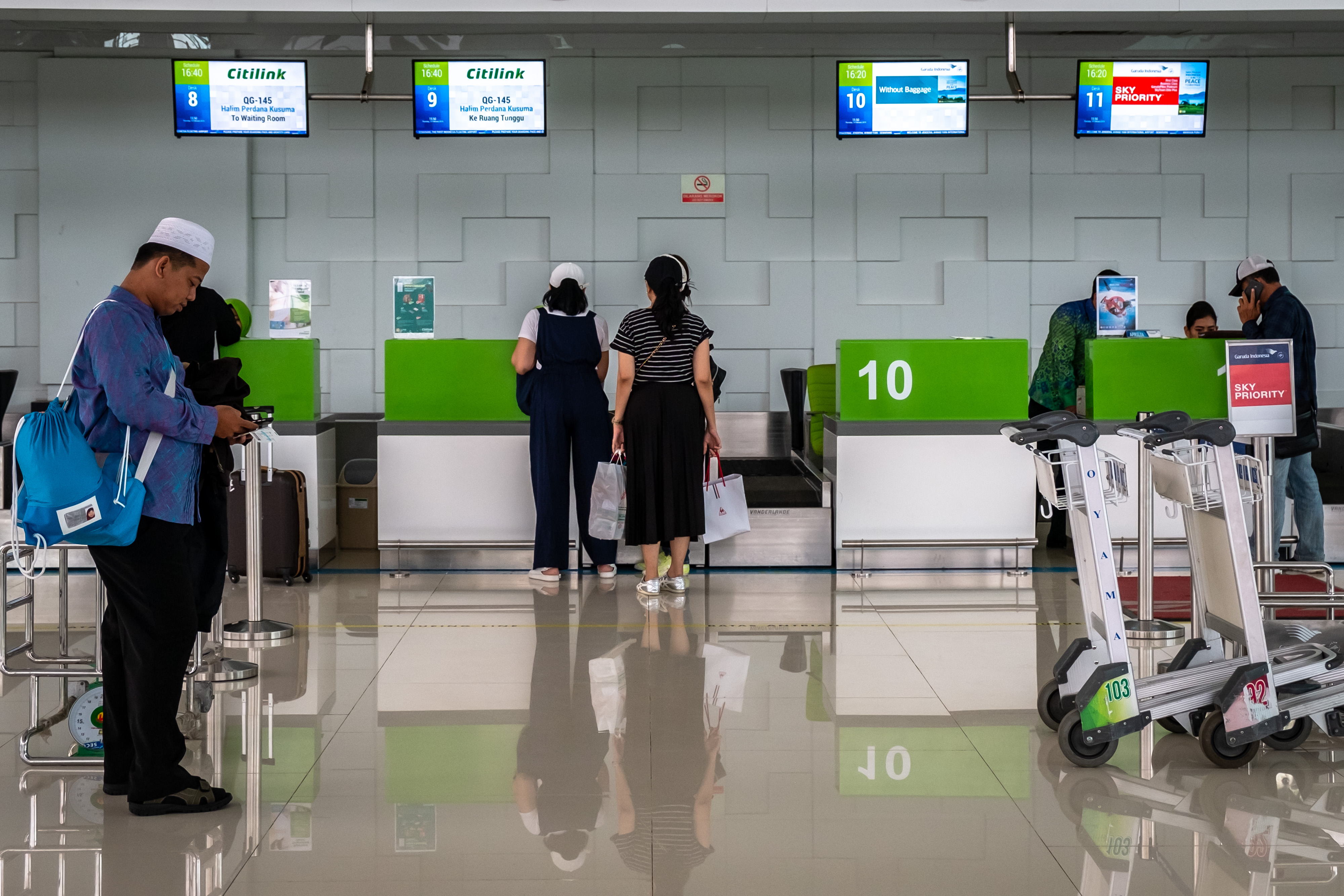 Penumpang beraktivitas di area check in atau konfirmasi tiket Bandara Internasional Jenderal Ahmad Yani, Semarang, Jawa Tengah