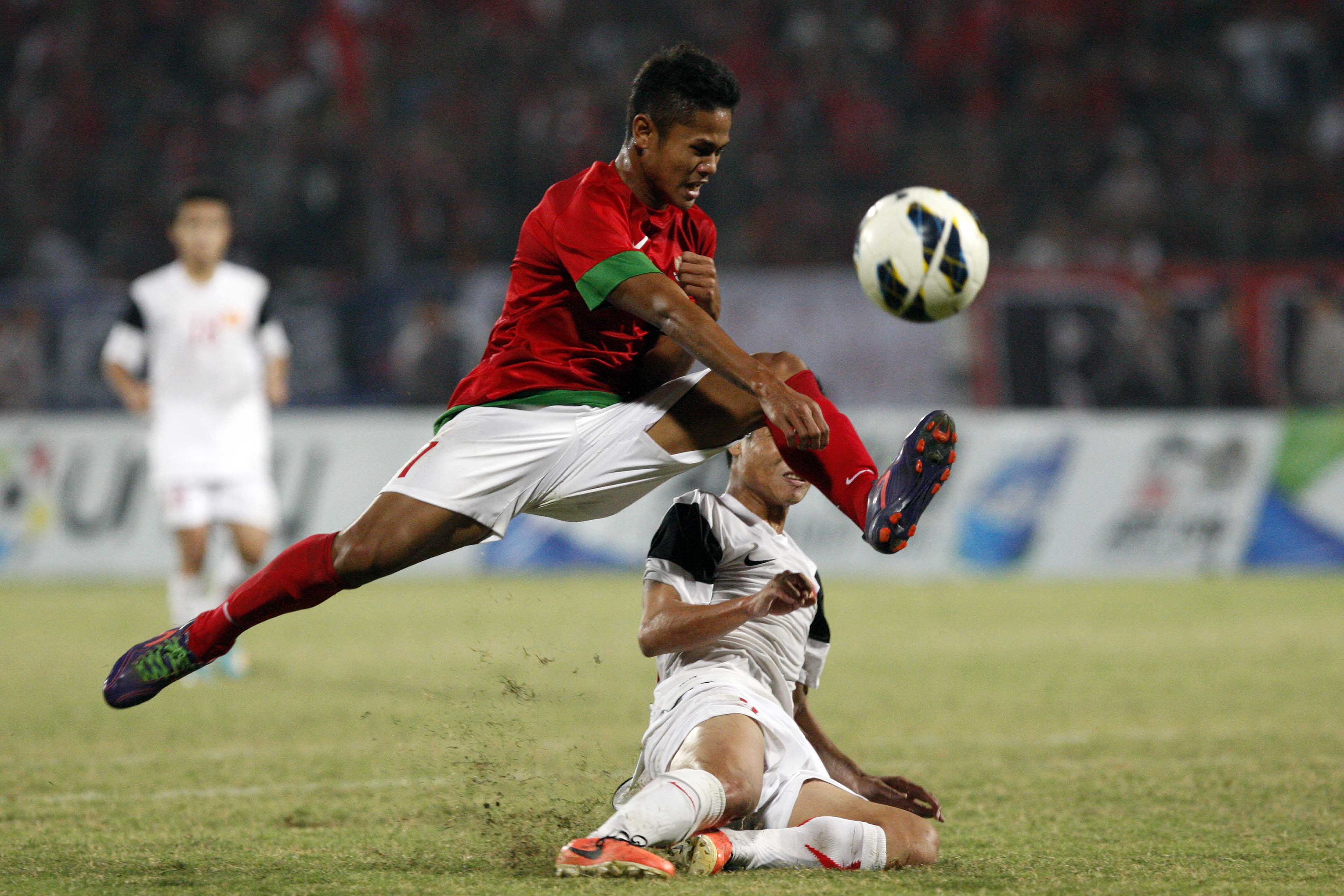 Pemain Indonesia U-19 Dimas Drajad (merah) berebut bola dengan pemain Vietnam