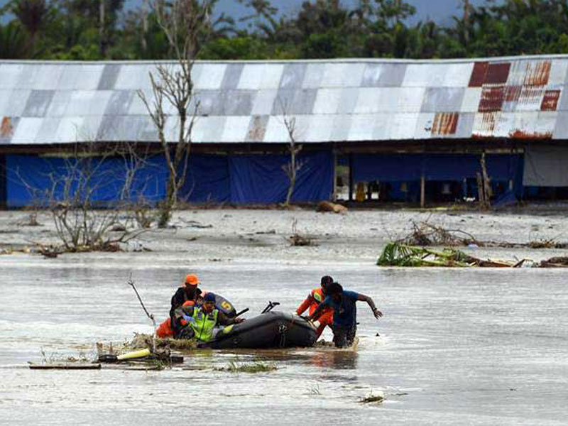 Tim SAR Gabungan mendorong perahu karet yang memuat jenazah korban banjir bandang Sentani