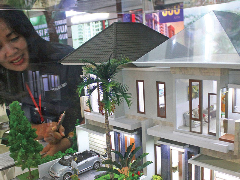 SEKTOR PROPERTI STABIL: Pramuniaga menunjukkan maket properti rumah hunian yang dipajang dalam Pameran Properti di Malang, Jawa Timur, bulan lalu. Politik nasional yang memanas dalam tiga bulan terakhir tidak memiliki pengaruh apa pun dalam penjualan produ