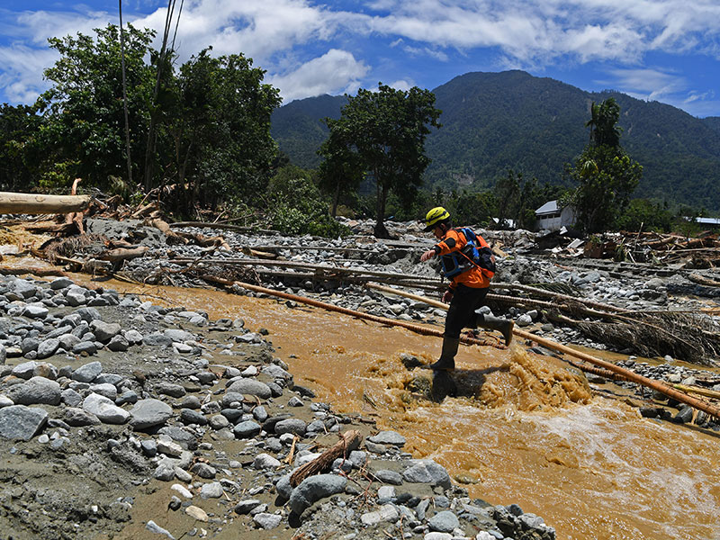 HARI KE TUJUH PASCABANJIR BANDANG SENTANI: Petugas Basarnas melintas di atas aliran sungai ketika mencari korban di Kampung Hinekomba, Sentani, Jayapura, Papua, Sabtu (23/3/2019)