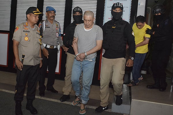 Sejumlah narapidana dikawal petugas menuju bus saat pemindahan narapidana di Lapas Kerobokan, Bali