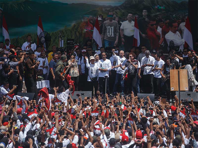 Calon Presiden nomor urut 01 Joko Widodo (tengah) bersama istri Iriana Joko Widodo menyapa pendukungnya saat Deklarasi Alumni Jogja Satukan Indonesia di Stadion Kridosono, DI Yogyakarta, Sabtu (23/3/2019). 
