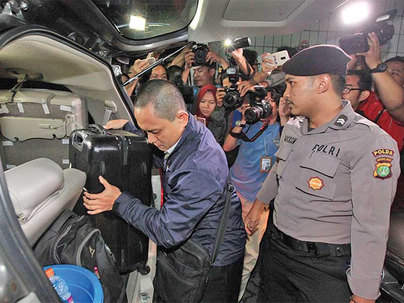 HASIL PENGGELEDAHAN: Petugas KPK dengan didampingi aparat kepolisian membawa tas koper seusai menggeledah Gedung Kementerian Agama, Jakarta, kemarin. Juru bicara KPK Febri Diansyah mengatakan petugas KPK dalam penggeledahan tersebut menyita sejumlah dokume