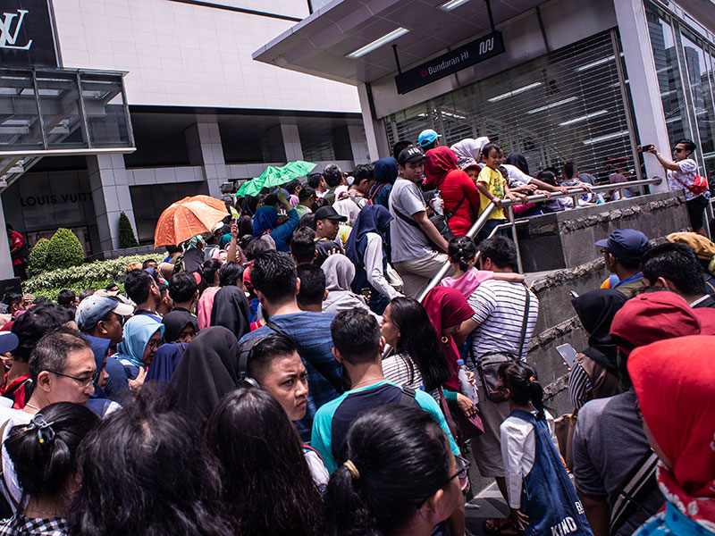 Warga mengantri untuk menaiki kereta MRT di pintu masuk Stasiun MRT Bundaran HI, Jakarta, Minggu (24/3/2019).