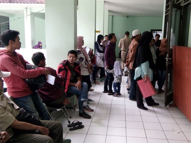 Masyarakat harus rela antri berada dilorong kantor Dinas Kependudukan dan Catatan Sipil menunggu proses penyelesaian percetakan KTP-E. 