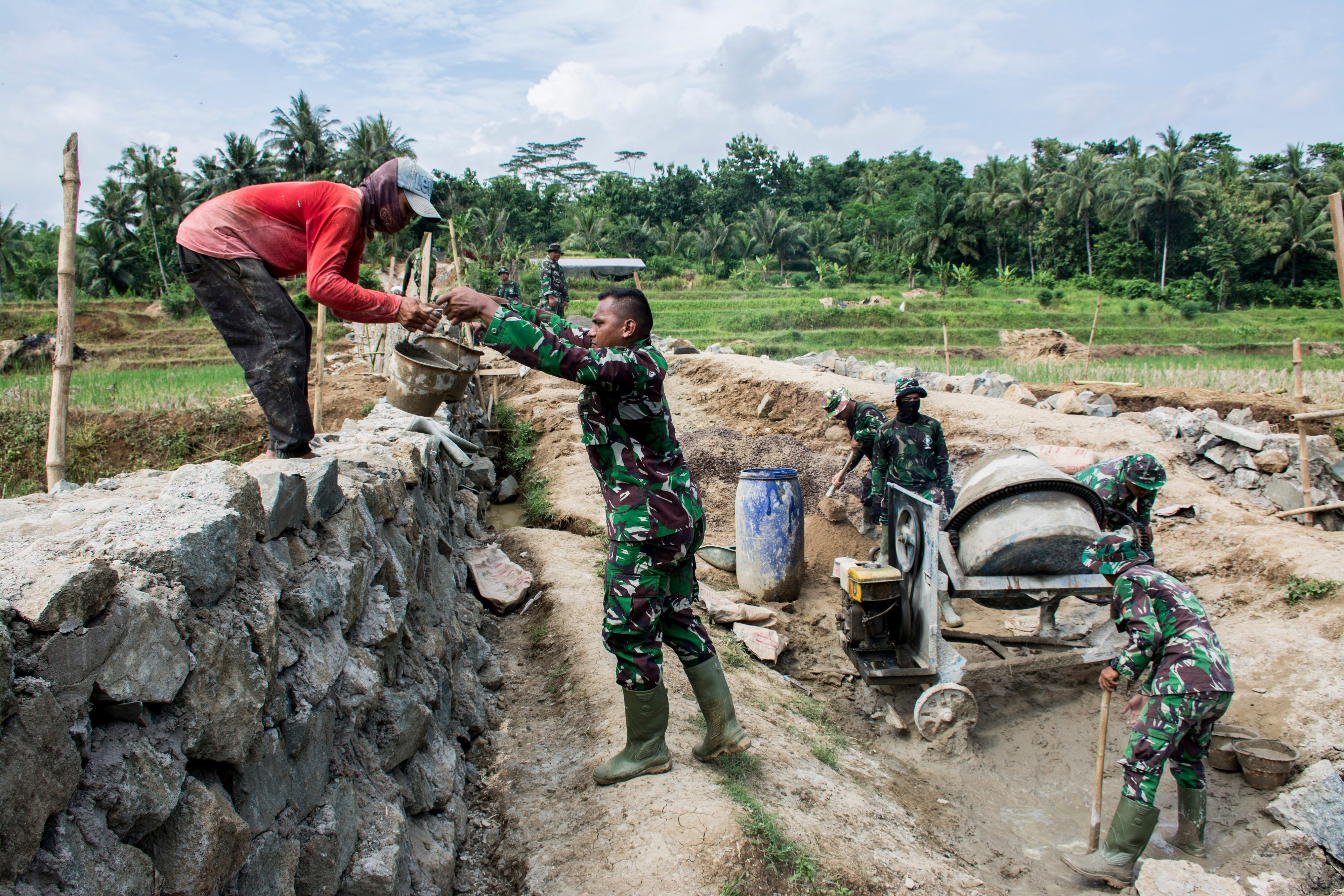 Sejumlah anggota TNI dan warga bergotong royong membangun jembatan antar Desa saat program Tentara Manunggal Membangun Desa (TMMD) 