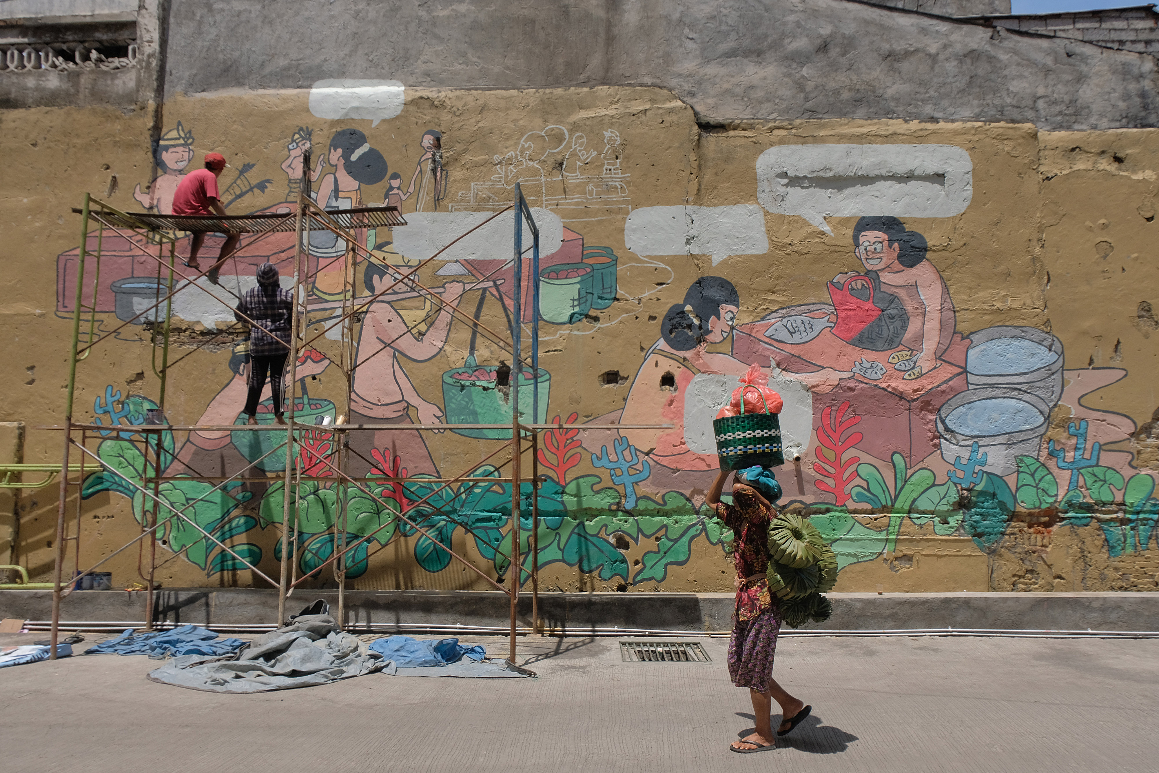Mahasiswa melukis mural pada tembok Pasar Badung menjelang diresmikan di Denpasar, Bali. 