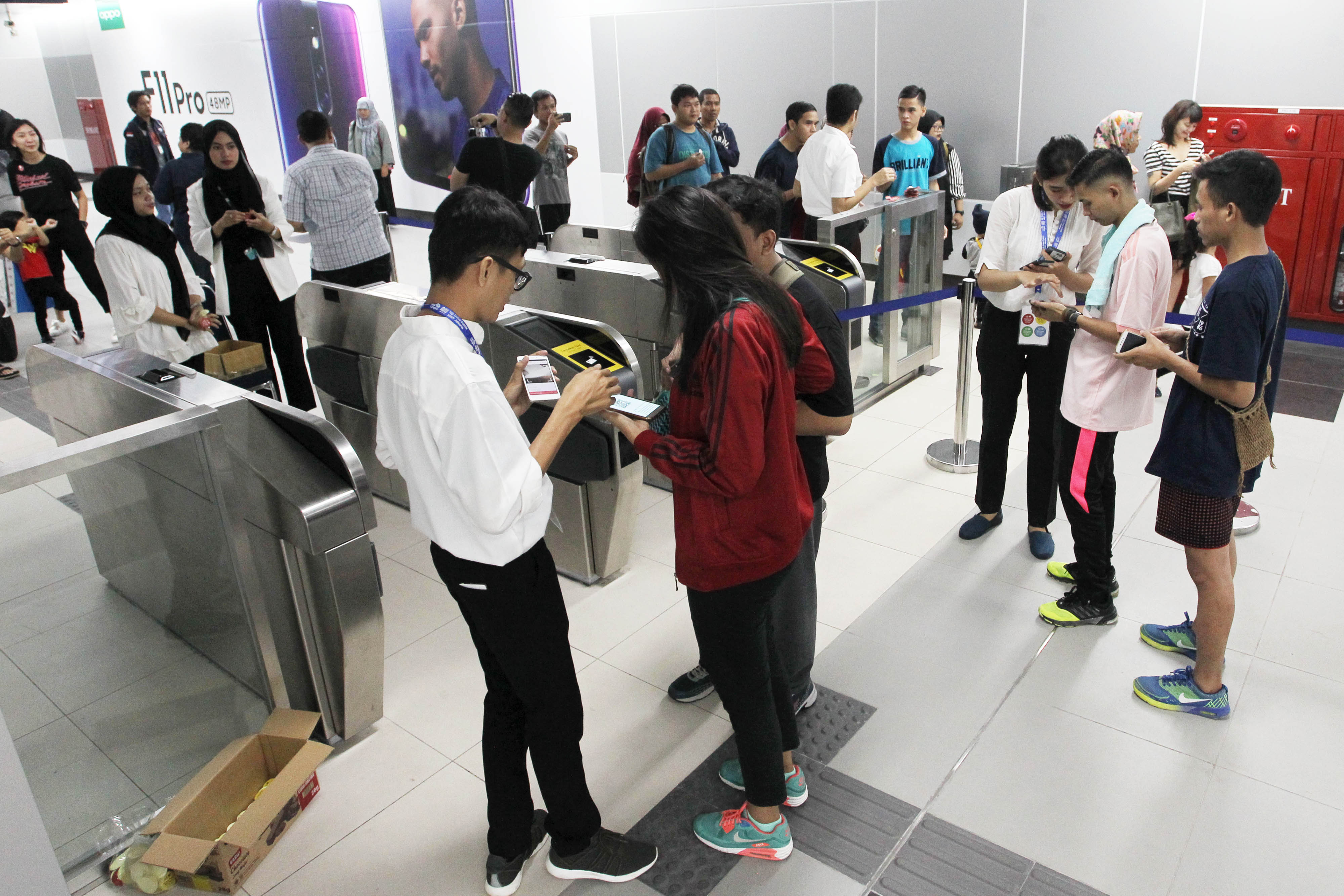 Petugas membantu warga yang akan menaiki Moda Raya Terpadu (MRT) dengan cara menunjukkan bukti pendaftaran saat akan mengikuti uji coba publik MRT di Stasiun Bundaran HI