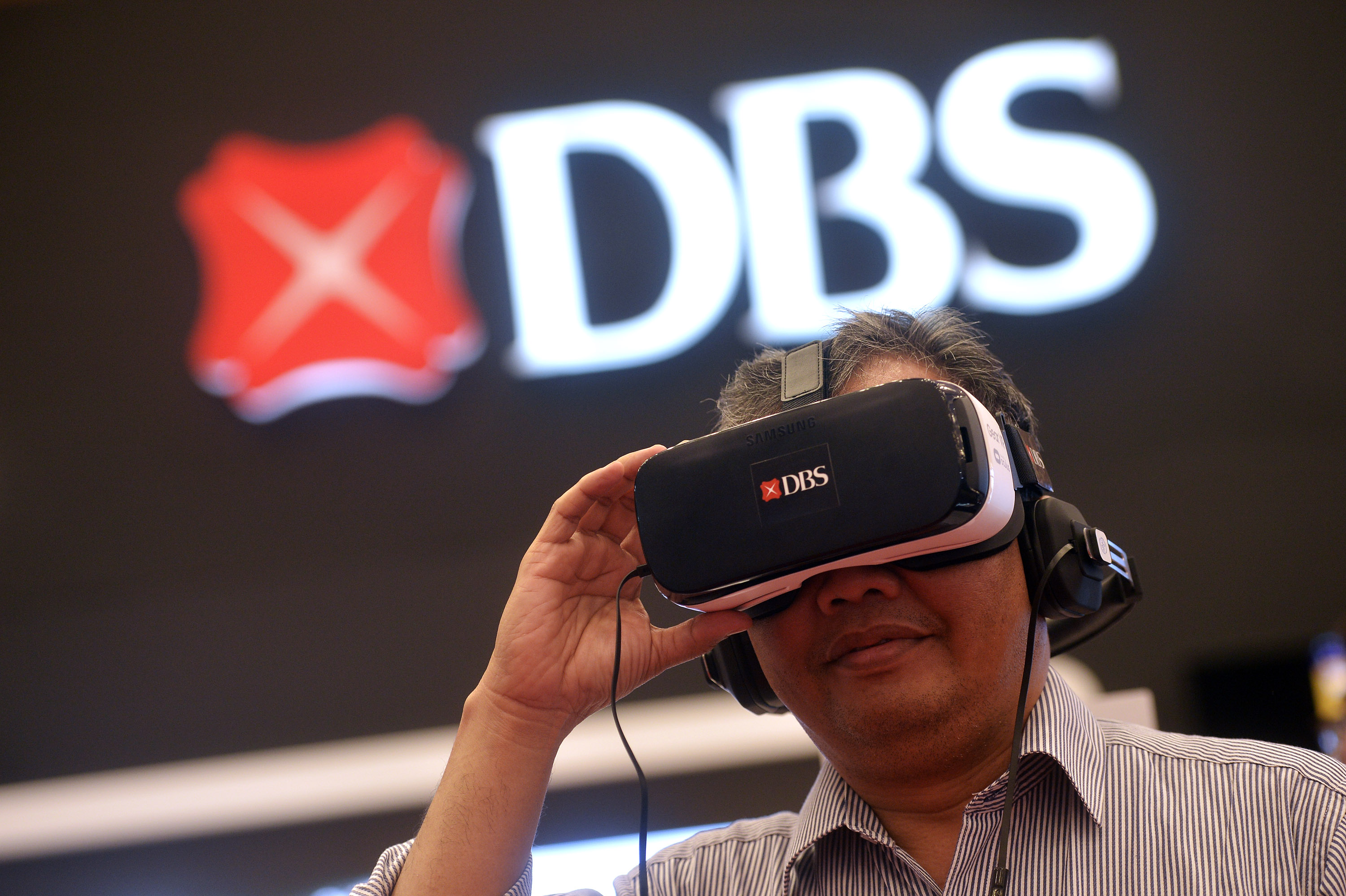 Pengunjung mencoba fitur layanan perbankan virtual di stan DBS Bank pada Indonesia Fintech Festival & Converence 