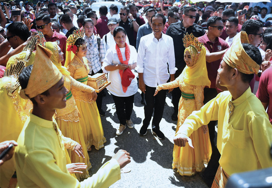 Joko Widodo beserta istri Iriana Widodo disambut tarian saat tiba di lokasi kampanye di Gedung Serbaguna Rambate Rata Raya, Asahan, Sumut.