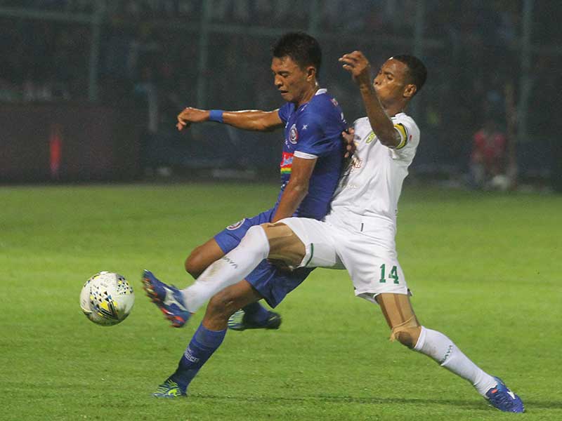 Pemain Arema FC, Dedi setiawan (kiri) berebut bola dengan pemain Persebaya Surabaya, Ruben Sanadi di leg kedua Final Piala Presiden.