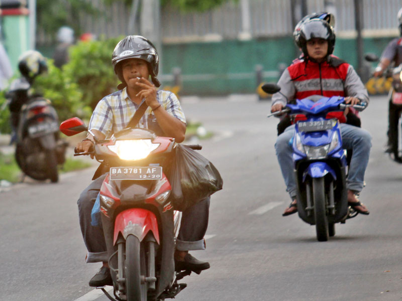 Sejumlah pengendara merokok sambil mengendarai sepeda motor