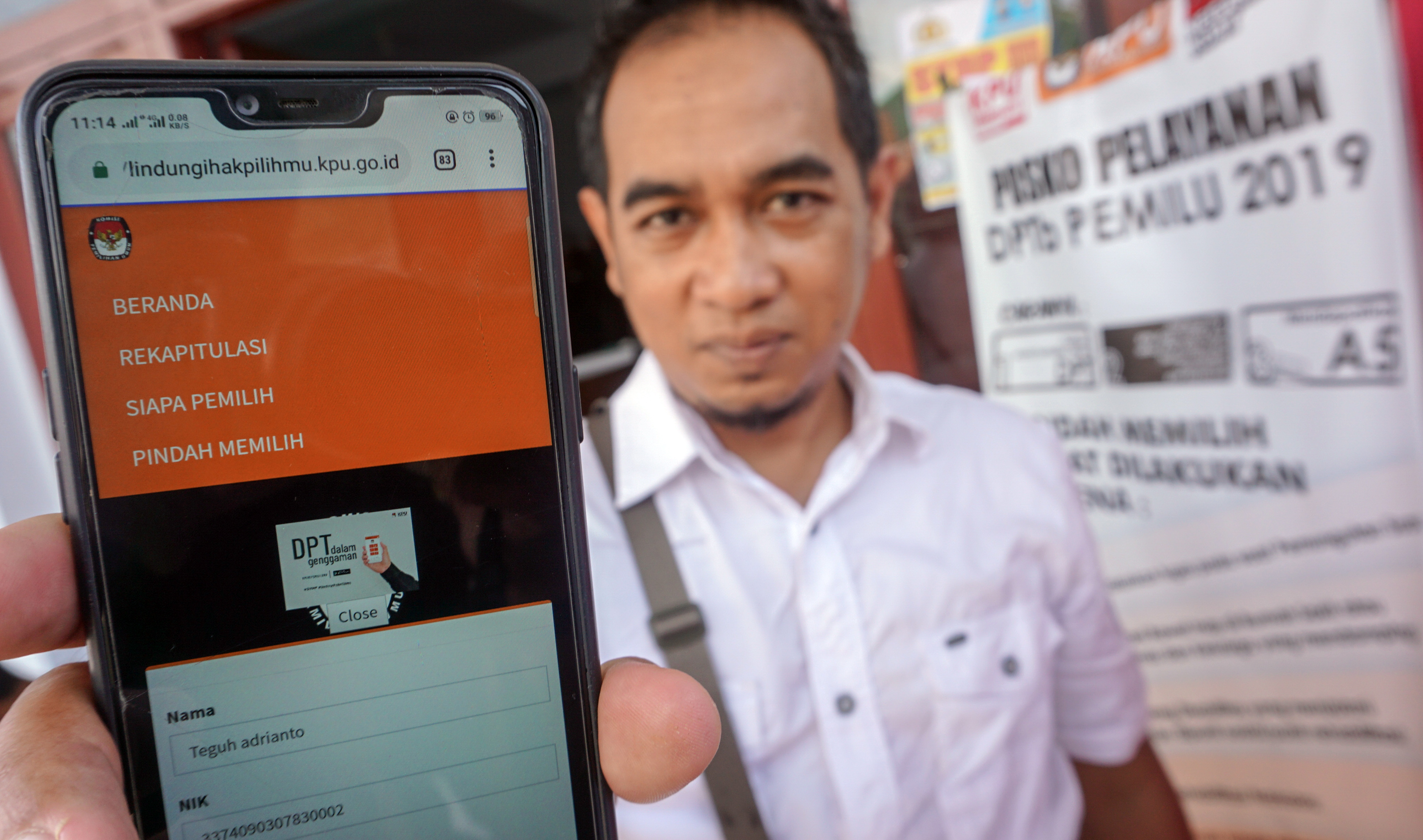 Seorang warga mengecek Daftar Pemilih Tetap (DPT) dengan gawainya di Kelurahan Jlamprang, Pekalongan, Jawa Tengah, Selasa (26/3)