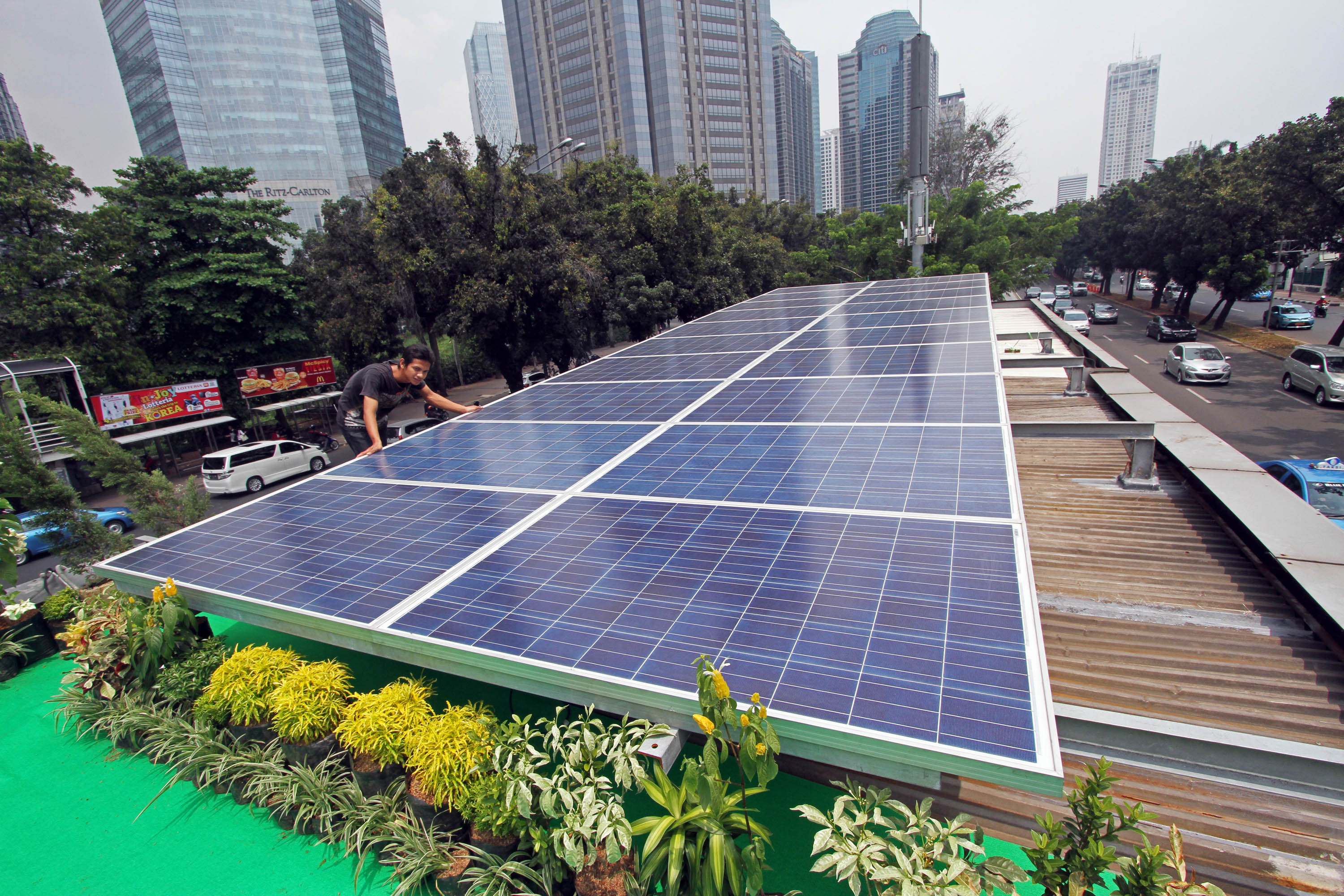 Petugas mengecek kondisi panel surya penghasil energi listrik saat peresmian konsep green building di atap halte Trans-jakarta Polda Metro