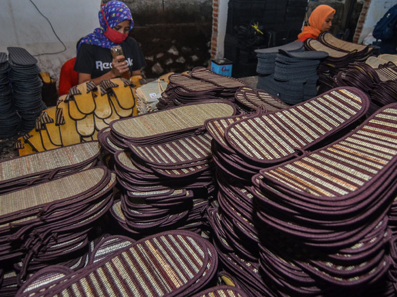 Pekerja menyelesaikan pembuatan alas kaki atau sandal berbahan mendong untuk fasilitas hotel