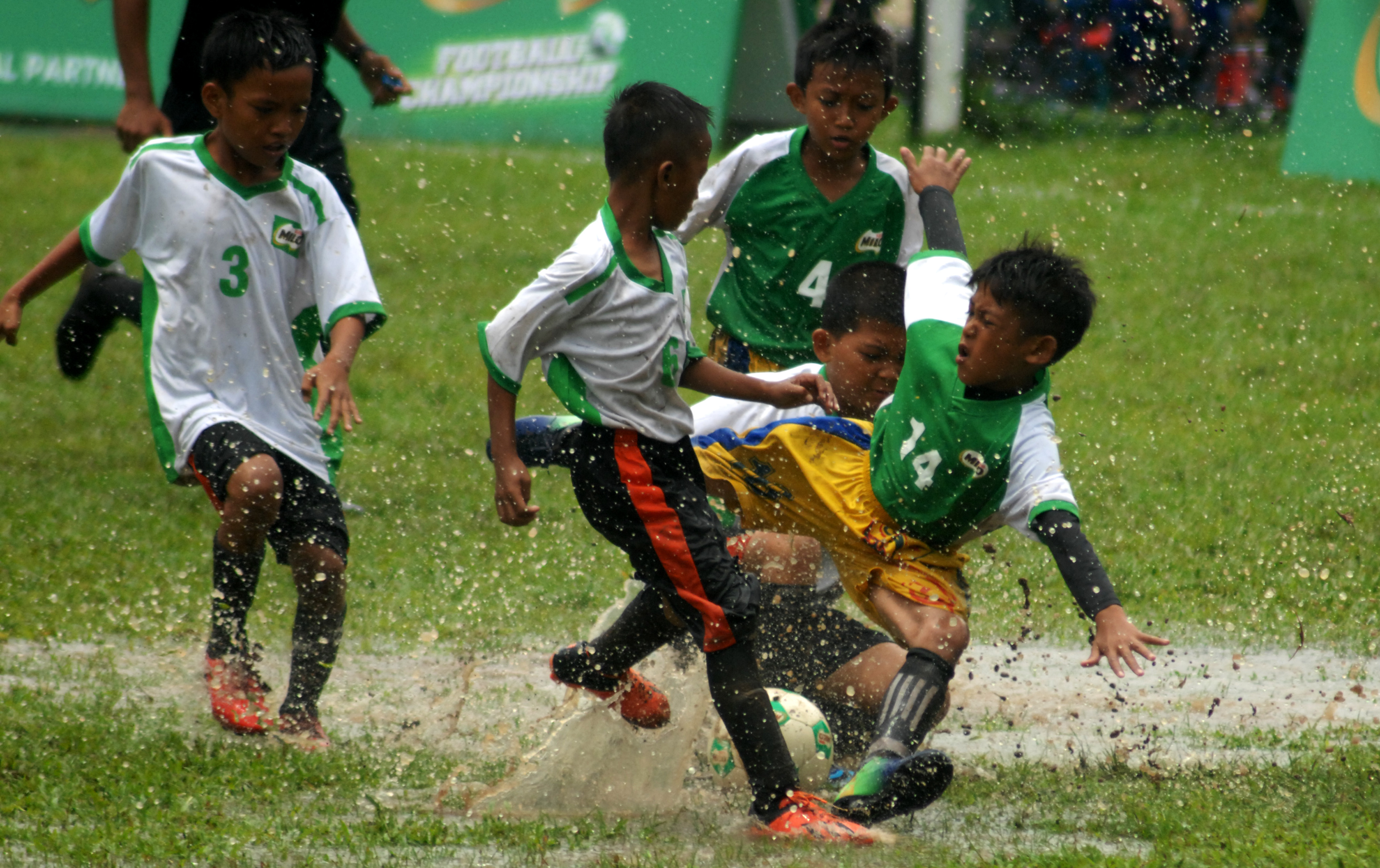 Anak-anak peserta kompetisi Milo Football Championship beradu ketangkasan memperebutkan bola di Lapangan Hasanuddin, Makassar