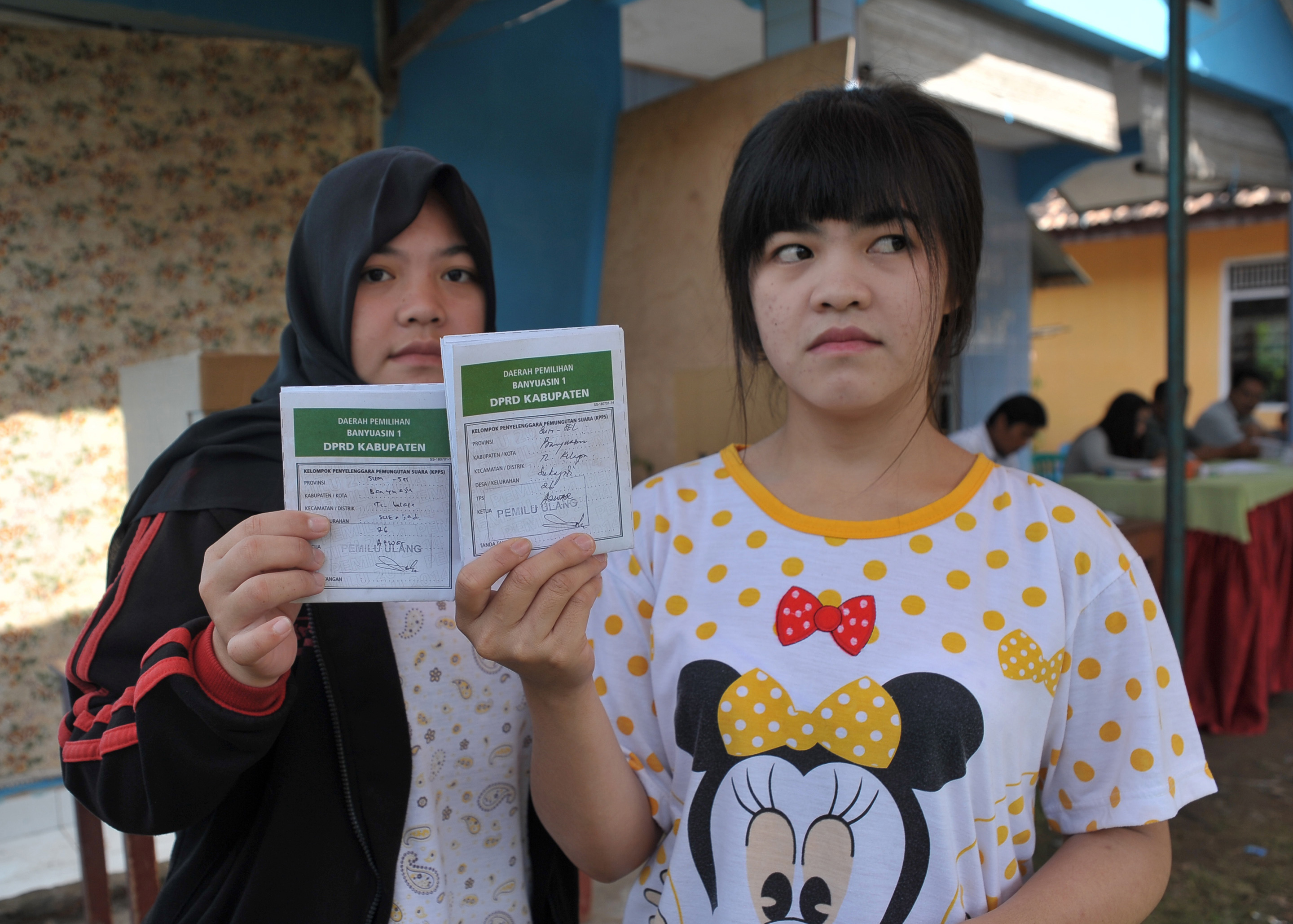 Warga menunjukkan surat suara yang akan dimasukkan ke kotak suara pada pemugutan suara ulangan (PSU) di TPS 26 kelurahan Sukajadi, Kecamatan