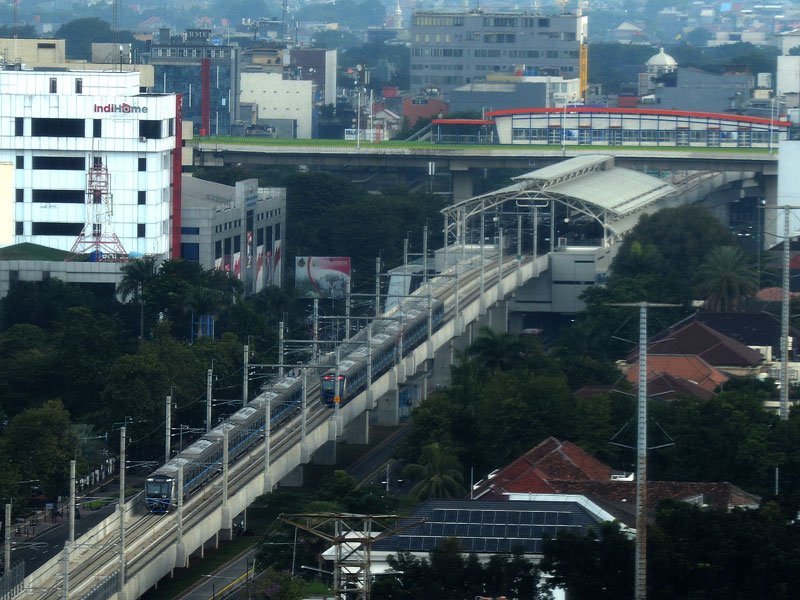 Dua rangkaian Moda Raya Terpadu (MRT) melintas dengan latar belakang Stasiun MRT Sisingamangaraja.