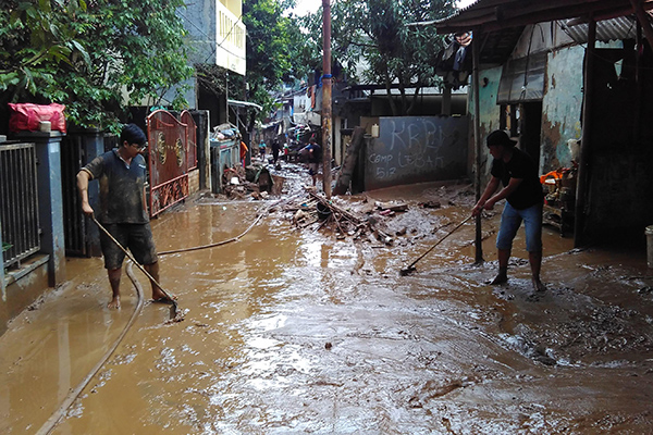 Warga sedang membersihkan sisa Banjir di Pejaten Timur