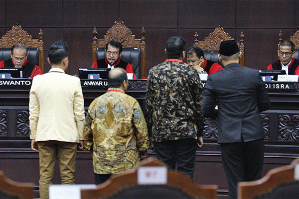 SIDANG LANJUTAN UJI UU OJK: Ketua Majelis Hakim Konstitusi (MK) Anwar Usman (kedua dari kiri) mengambil sumpah empat saksi saat memimpin sid