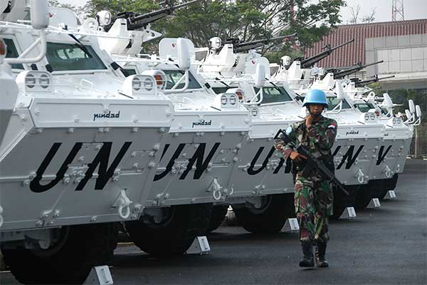 Prajurit TNI berjalan di depan Panser Anoa 6x6 di sela-sela penyerahan 24 unit Panser tersebut dari PT Pindad di markas Pusat Misi Pemelihar