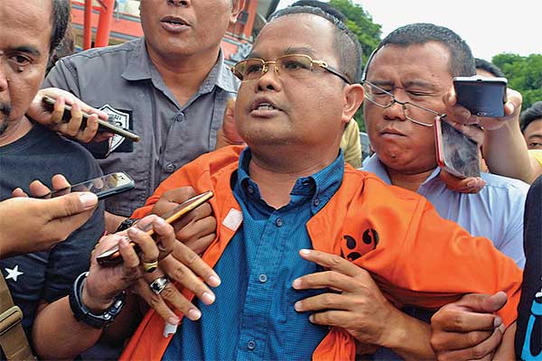 KETUA KADIN BALI DITAHAN: Ketua Kamar Dagang dan Industri (Kadin) Bali, Anak Agung Ngurah Alit Wiraputra, dikawal petugas menuju ruang tahan