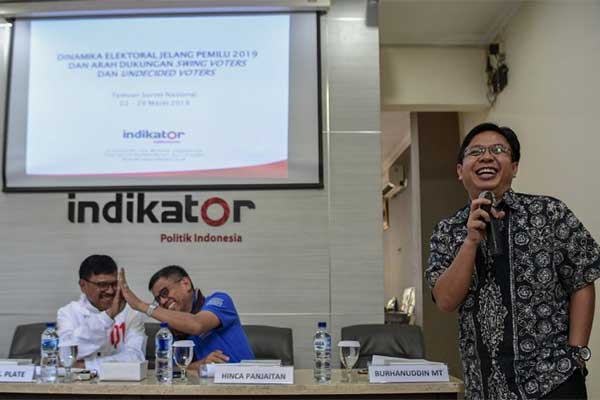 Direktur Eksekutif Indikator Politik Indonesia Burhanuddin Muhtadi (kanan) disaksikan Sekjen Partai Demokrat Hinca Panjaitan (tengah) dan Se