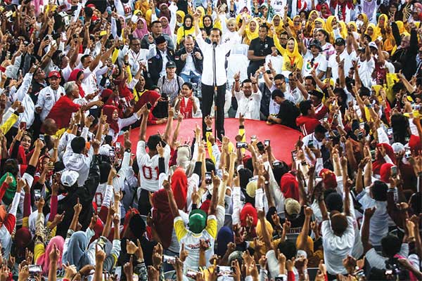 AJAK PENDUKUNG PENUHI TARGET: Calon presiden nomor urut 01 Joko Widodo menyapa para simpatisan saat kampanye terbuka di Gedung PLUT, Cikemba