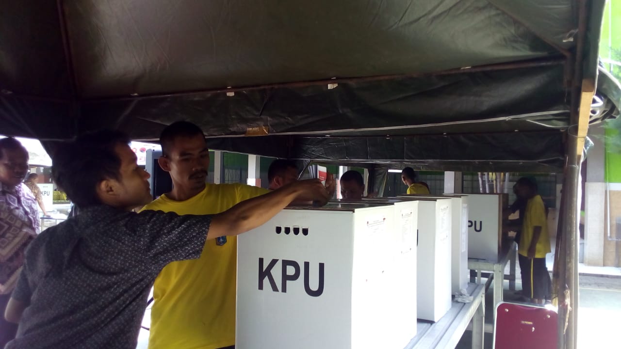 Seorang warga binaan Panti Sosial Bina Laras memasukkan surat suara ke kotak suara.