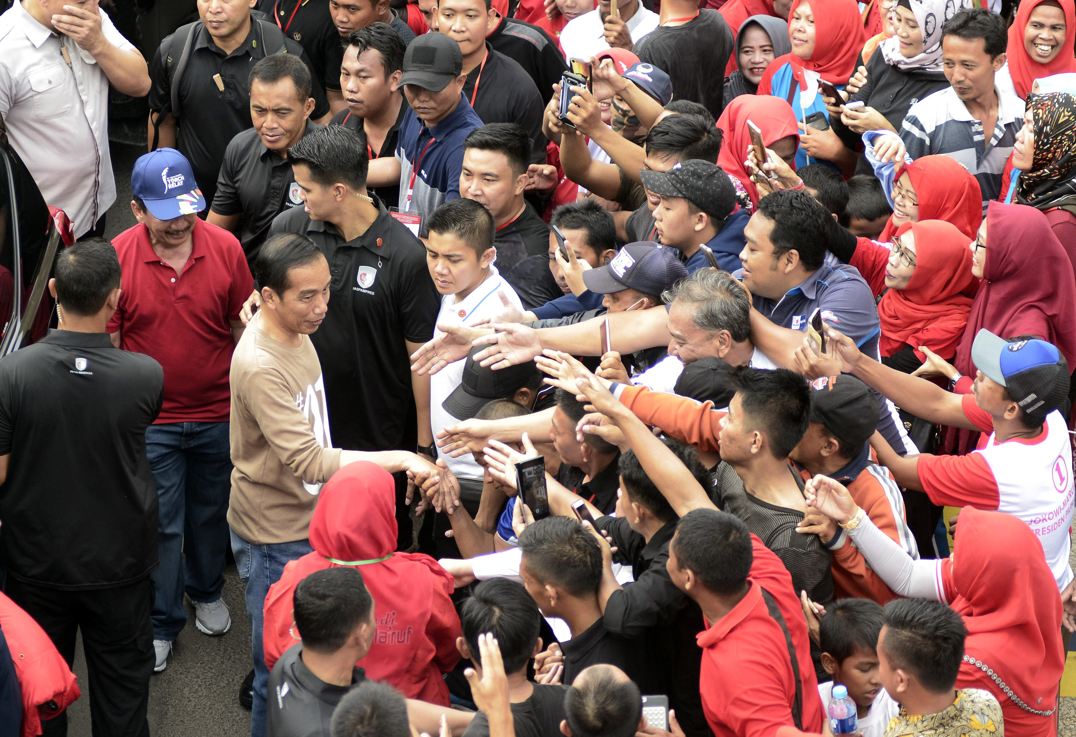 Masyarakat berebut untuk bersalaman dengan capres 01 Joko Widodo saat kegiatan jalan sehat di Tugu Adipura, Lampung, Sabtu, (24/11).