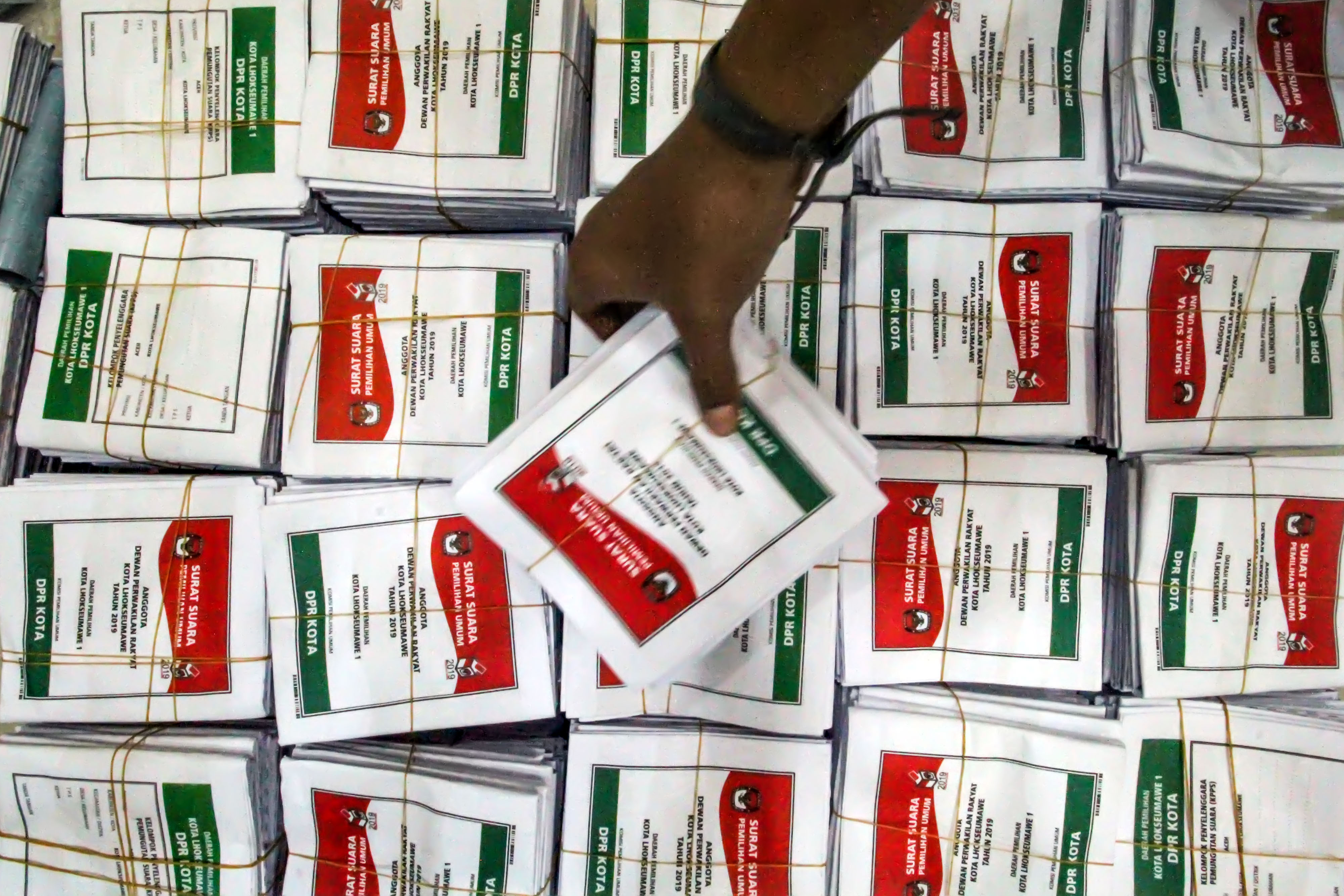 Pekerja lepas melakukan penyortiran dan pelipatan surat suara pengganti dan tambahan di KIP Lhokseumawe