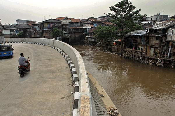 Warga melintasi bantaran Sungai Ciliwung 