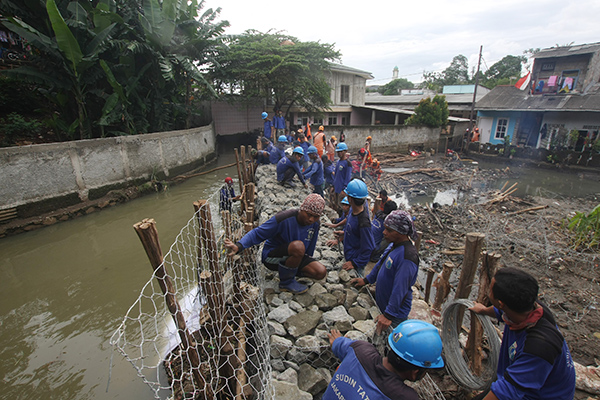 Petugas gabungan dari Dinas Sumber Daya Air dan Dandim Jakarta Selatan memperbaiki tanggul kali Pulo yang jebol