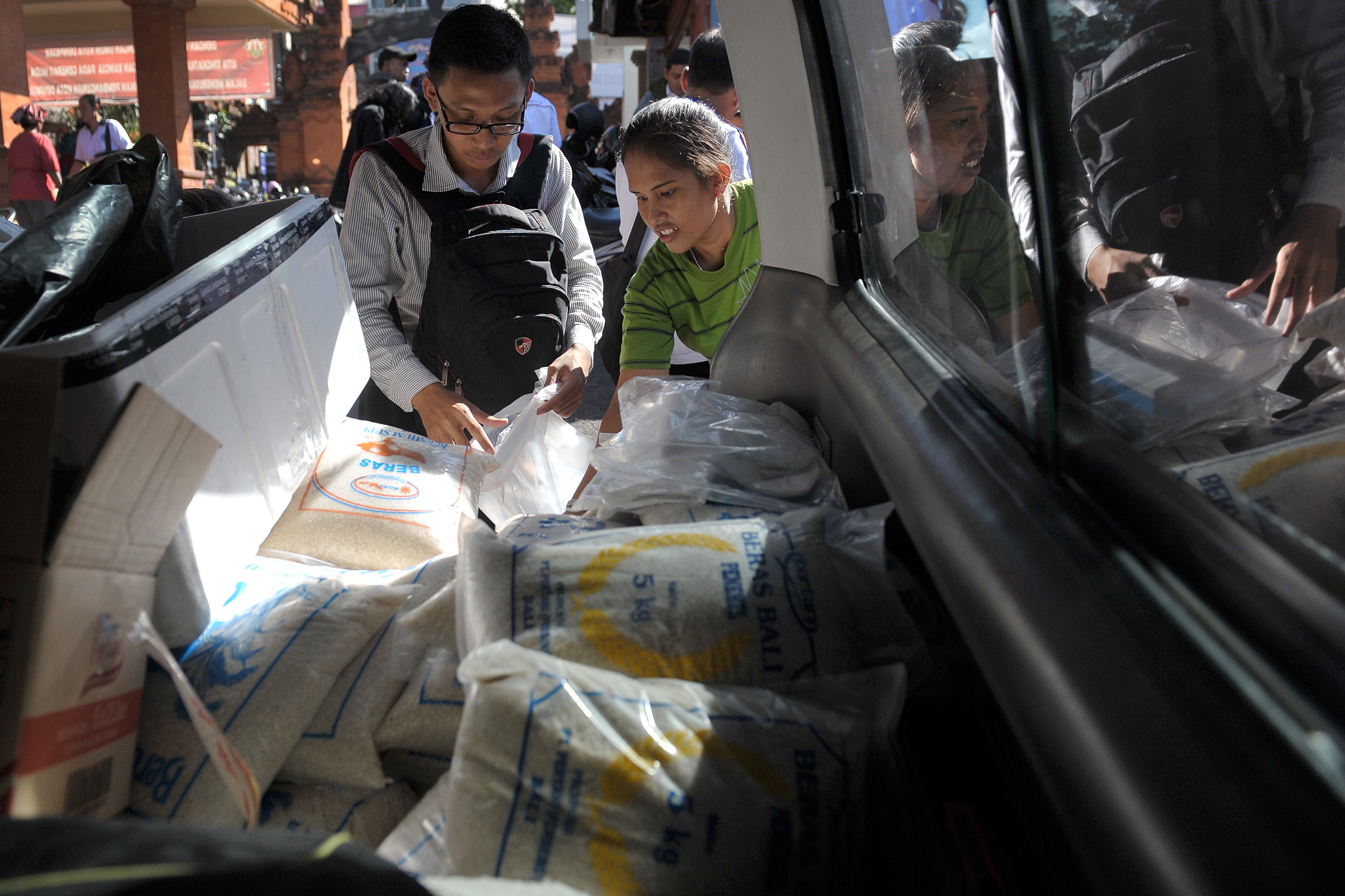  Petugas Perum Bulog Divisi Regional Bali melayani warga yang memerlukan kebutuhan pokok saat operasi pasar sembako