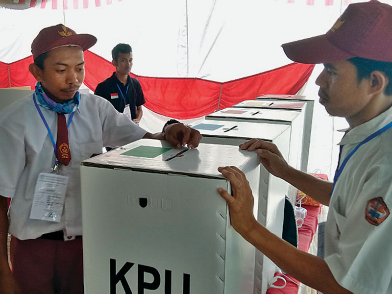 Petugas PPS dengan kostum seragam sekolah dasar (SD) bersiap melayani warga yang hendak menggunakan hak pilihnya di Pangkalpinang,Babel.