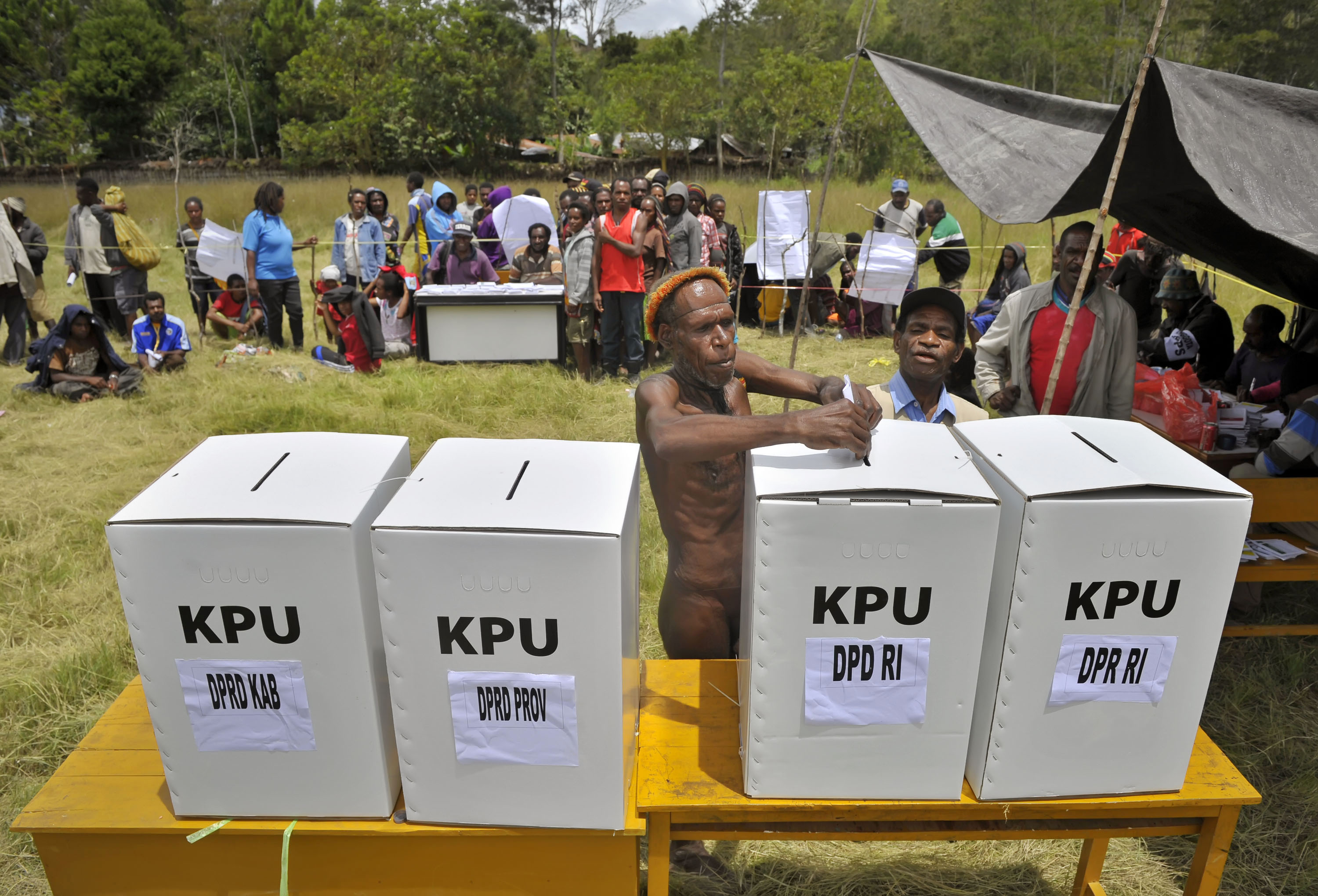 Warga pedalaman memasukkan kertas suara usai mencoblos pada pemungutan suara Pemilu Legislatif 